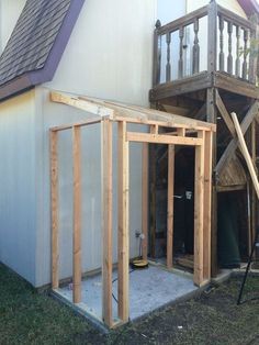 a house being built with wooden framing on the front and side walls, next to a deck