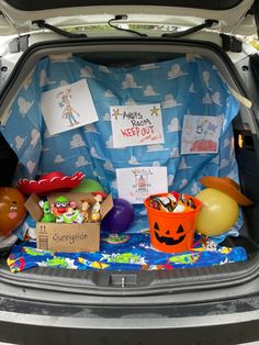 the trunk of a car is filled with toys and decorations