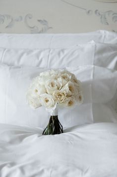 a bouquet of white flowers sitting on top of a bed