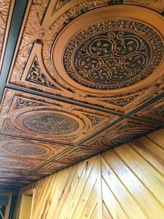 an ornate ceiling with wood paneling and decorative designs on the top part of it