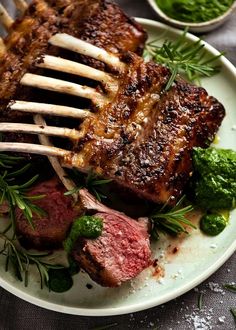 a white plate topped with steak and broccoli on top of a wooden table