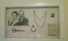 a white frame with some pictures on it and a clock hanging from the wall next to them