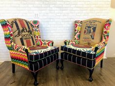 two colorful chairs sitting on top of a hard wood floor next to a white brick wall