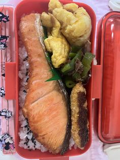 a plastic container filled with food on top of rice