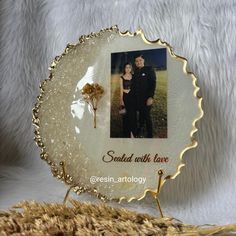 a glass plate with an image of a man and woman on it, sitting next to a wheat field