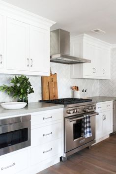 a kitchen with white cabinets and stainless steel appliances