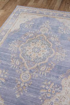 a blue rug with an ornate design on the top and bottom, sitting on a wooden floor