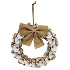 a wreath with seashells and a bow hanging on a rope