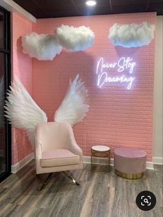 a pink room with angel wings on the wall