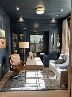 a living room filled with furniture and a large painting on the wall above it's fireplace