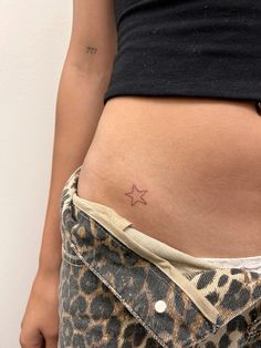 a woman's stomach with a small star tattoo on it