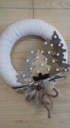 a christmas wreath made out of felt and fabric with a small tree on the front