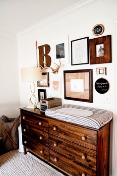 a baby crib in the corner of a room with many pictures on the wall