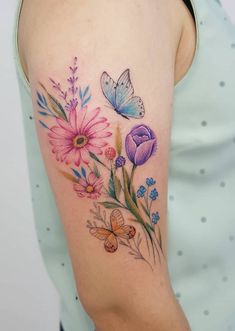 a woman's arm with colorful flowers and butterflies on the left side of her arm