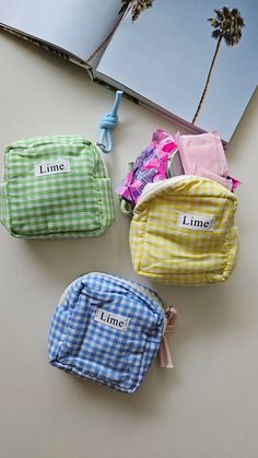 four small pouches with the word lime on them sitting next to an open book