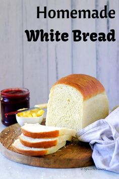 a loaf of white bread sitting on top of a wooden cutting board next to jam