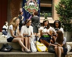 several young women sitting on the steps talking