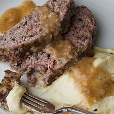 meatloaf, mashed potatoes and gravy on a plate with a fork