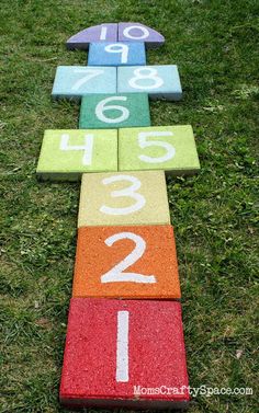 a number line made out of colored blocks on the grass with numbers painted on it