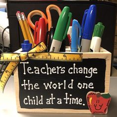 a teacher's change the world done child at a time sign with school supplies in it