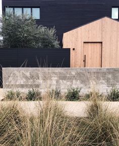 an instagramted photo of a house with grass in the foreground and bushes on the other side