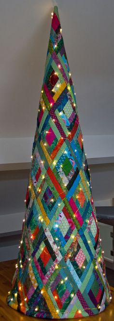 a multicolored christmas tree sitting on top of a wooden table