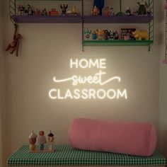 there is a neon sign that says home sweet classroom on the wall above a bench