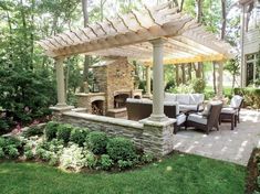 an outdoor living area with stone fireplace and seating