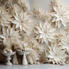 white paper flowers are on display in front of a wall