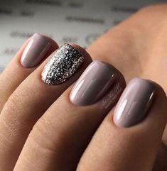 Beautiful manicure with a purple-based mauve-gray color, and a sparkly silver accent nail. Perfect for the holidays. Gray And Sparkle Nails, Neutral Manicure With Accent Nail, Nail Colors With Accent Nail, Muted Lavender Nails, Fall Nails Sparkle Accent, Short Oval Glitter Nails, Dark Dipped Nails, November Dip Nails 2023, Holiday Manicure Ideas Classy