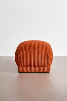 an orange corded bag sitting on top of a table next to a white wall