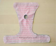 a pink and white striped cloth with a hole in the middle on a wooden surface