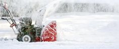 a man using a snow blower to clear the snow