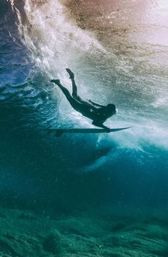 a man riding a wave on top of a surfboard in the ocean under water