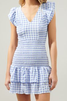 Go gingham in this perfectly smocked detail mini dress. Ruffle layer cap sleeves frame a V neckline and partially smocked bodice with princess seams to add a shapely figure. Smocking continues throughout the drop waist and ruffle layer details to finish off the dress. Pair it with pointed toe heels and a mini shoulder bag for a charming ensemble.- Ruffle layer details- Smocked- Princess seams- Drop waist- Comes in 2 ColorsSize + Fit - Model is 5'8" and wearing size XS- Measurements taken from si Gingham Dress With Ruffle Hem And Square Neck, Gingham Mini Dress With Ruffles And Square Neck, Gingham Dress With Smocked Bodice And Short Sleeves, Short Sleeve Gingham Dress With Smocked Bodice, Gingham Short Sleeve Dress With Smocked Bodice, Gingham V-neck Dress With Ruffles, Short Sleeve Gingham Smocked Dress, Short Sleeve Gingham Smocked Dress For Summer, Fitted Gingham Smocked Dress With Short Sleeves