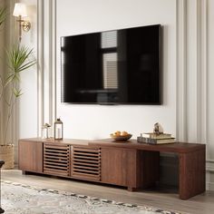 a flat screen tv mounted to the side of a wooden entertainment center in a living room