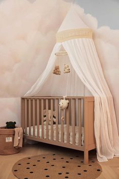 a baby's room with a canopy over the crib and teddy bears on the floor