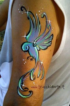 a colorful bird painted on the arm of a woman's left arm and shoulder