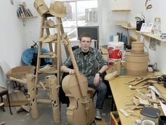 a man sitting in a room with lots of musical instruments