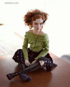 a doll sitting on top of a wooden table