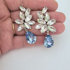 "Elegant Vintage style Bridal Earrings. Made with high-quality Crystal rhinestones in light blue and clear crystals. Gorgeous and elegant floral-inspired drops. Pair them with a cocktail dress or an over-sized sweater for an everyday look. Rhodium silver plated 2\" length, 1\" width Glass crystals Surgical steel posts, hypoallergenic" Blue Cubic Zirconia Chandelier Earrings For Party, Blue Rhinestone Crystal Earrings For Wedding, Blue Statement Earrings, Blue Chandelier, Bridal Statement Earrings, Handmade Chandelier, Crystal Cuff Bracelet, Wedding Jewelry Earrings, Clear Crystals