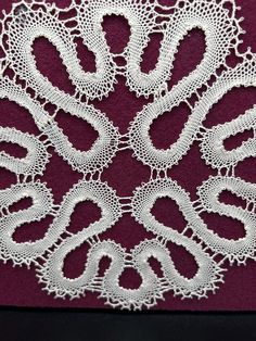 a white lace doily on a red background with the word love written in cursive writing