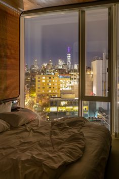 a bedroom with a view of the city at night