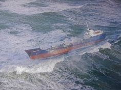 a large boat in the middle of some choppy ocean water with waves around it