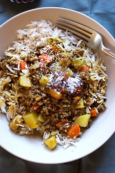 a white plate topped with rice and vegetables