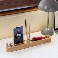 a cell phone and pen holder on a desk