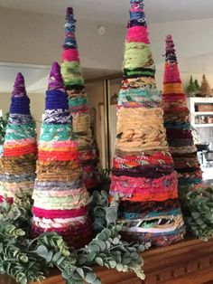 several stacks of yarn sitting on top of a wooden mantle next to a potted plant