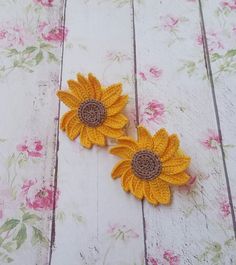 two crocheted sunflowers sitting on top of a table