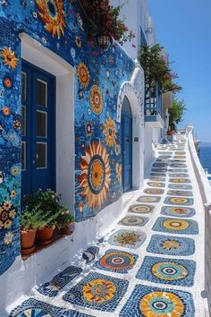 a blue and white building with sunflowers painted on the wall next to it