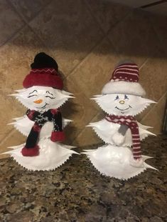 two snowmen sitting next to each other on a counter